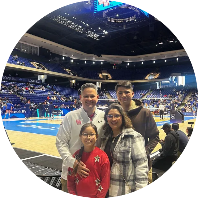 Coach Felicia Rehr with her family in the stands at a professional volleyball match.